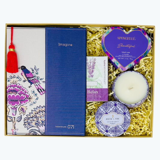 Gift set with a journal, candle, aromatherapy roller ball,  and lavender Spongelle in a decorative box.
