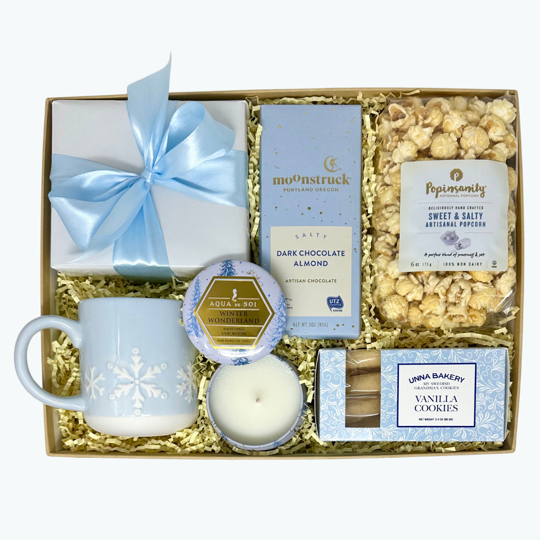 Gift set with mug, candle, chocolate, cookies, and popcorn in a box.