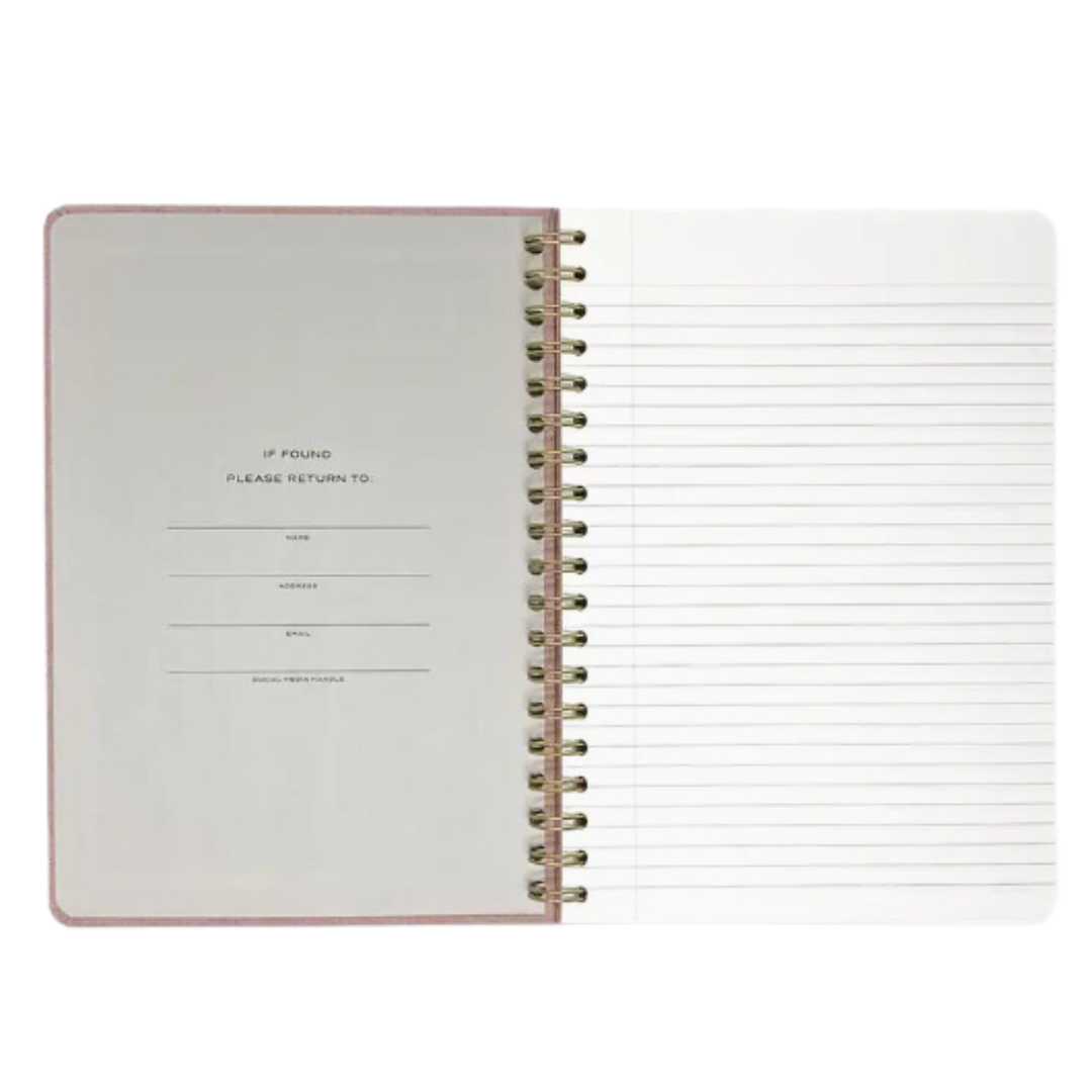 Pink linen spiral journal, 7x10 inches, lying open with blank pages that are lined.