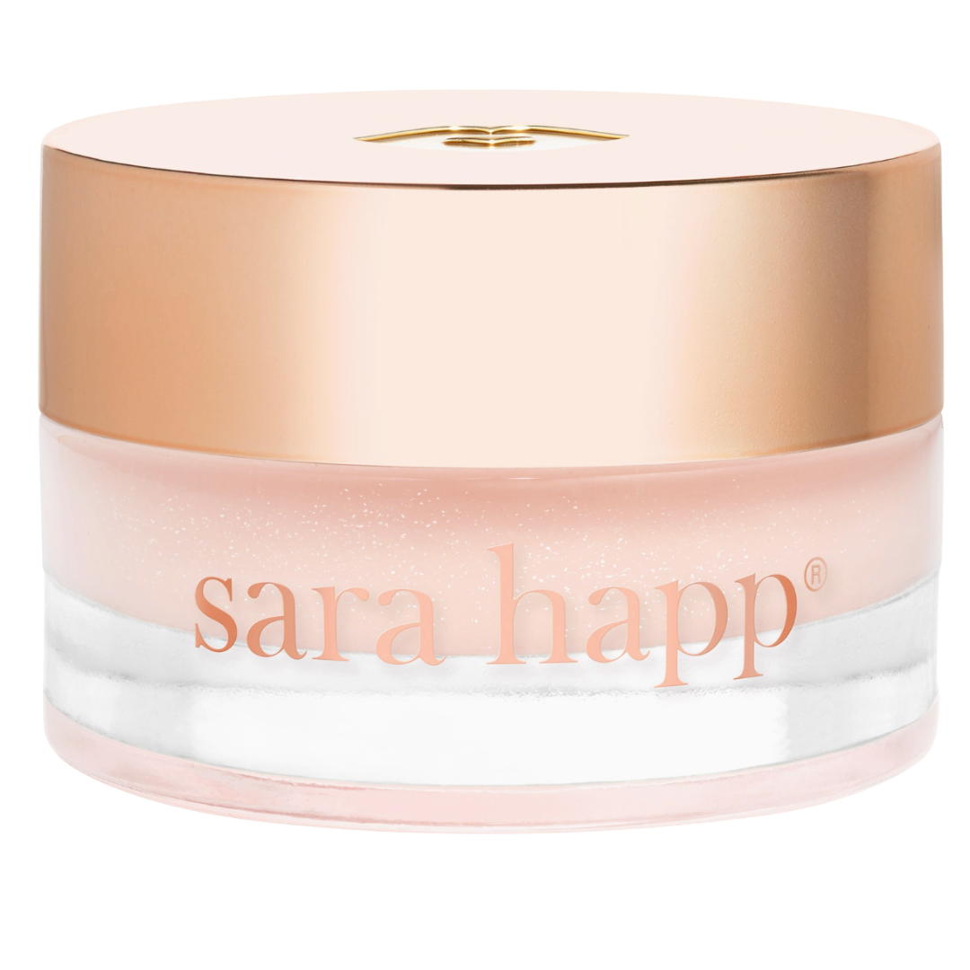 Sara Happ skincare lip product with gold cap and glass container on a white background.
