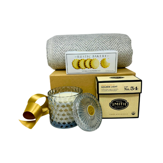 Gift set with candle, mug, tea and blanket on a white background.