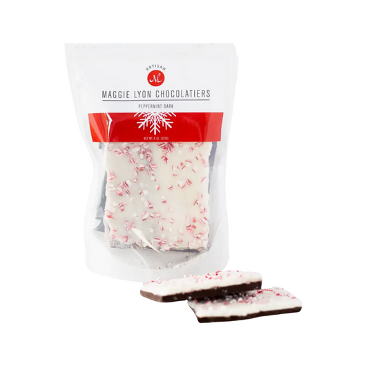 Close-up of Maggie Lyon Chocolatiers Peppermint Bark packaging. The 8-ounce bag displays the layers of dark and white chocolate with peppermint crunch on top. The ingredients list includes dark and white chocolate, peppermint oil, and other components.