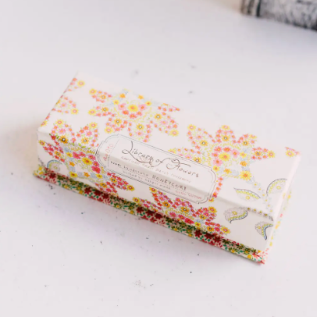 Floral-patterned handcreme with branding on a white surface