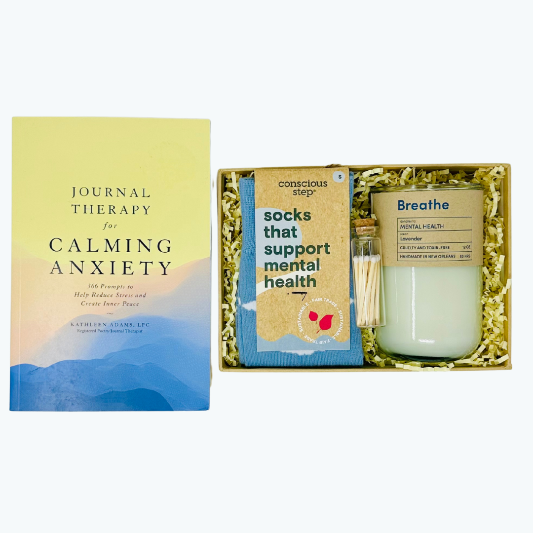 Gift set with guided journal, socks, matches and candle in a box on a white background.