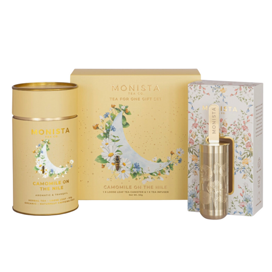 Organic camomile tea set in yellow packaging with elegant gold infuser for a luxurious tea experience.