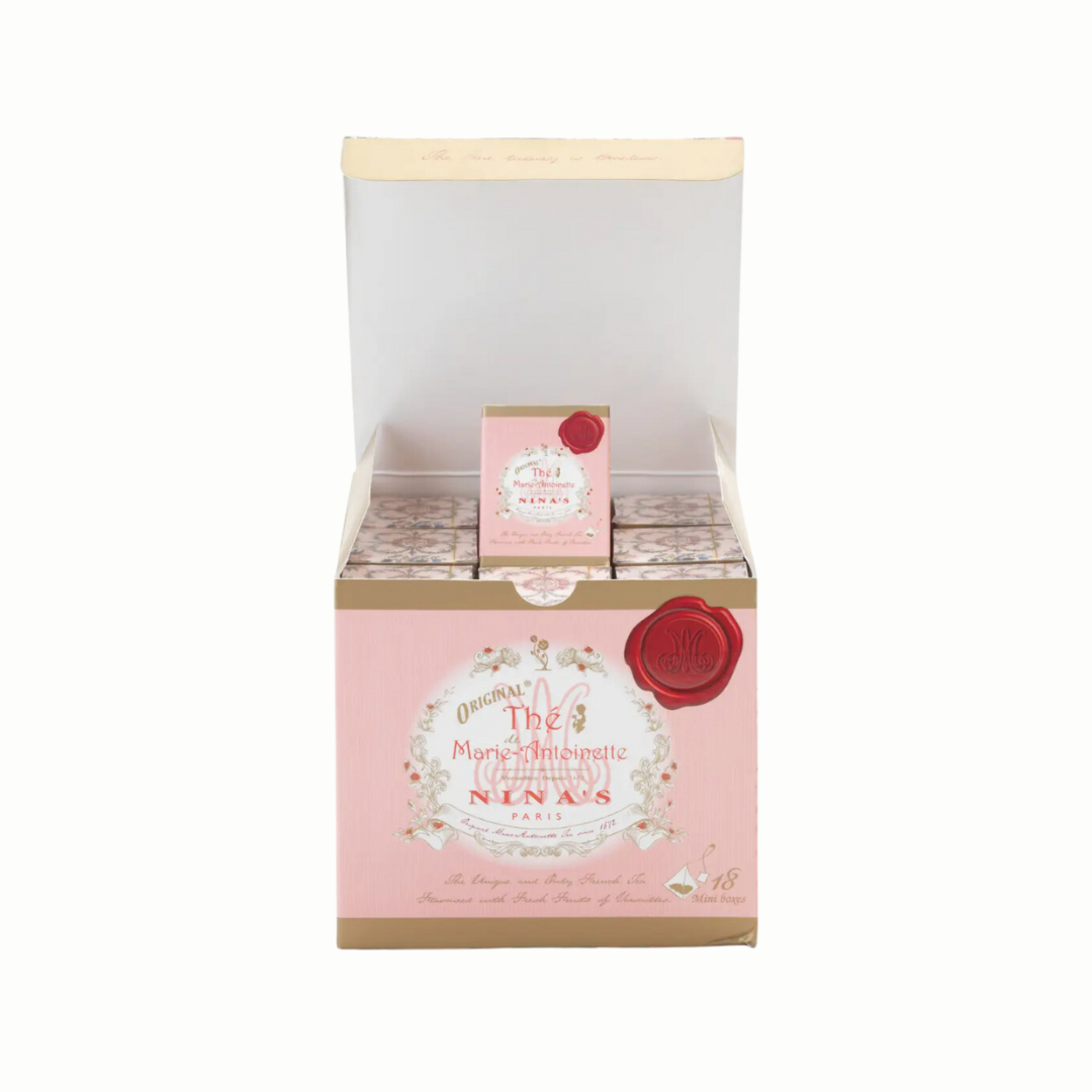 Elegant gift set of Nina's Paris Marie Antoinette Tea featuring 18 miniature pink boxes, each containing a single tea bag. The decorative gift box showcases a refined design with intricate details, reflecting the luxurious blend of Ceylon tea, rose petals, and apple essence, accented with rose from Versailles.