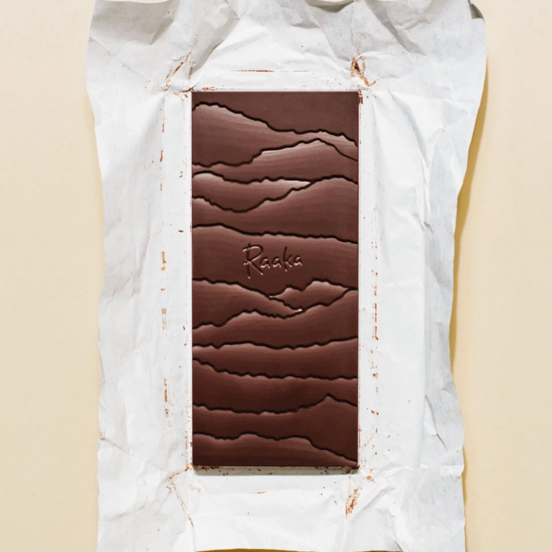 Chocolate bar with a textured surface on a white paper background.