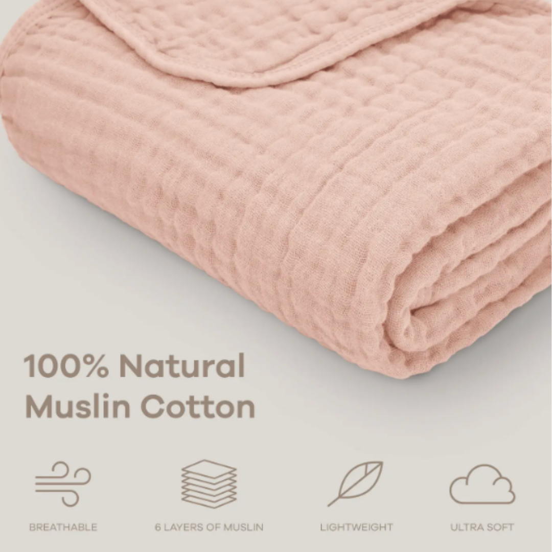 Folded pink muslin cotton blanket on a light gray background with text highlighting its features.
