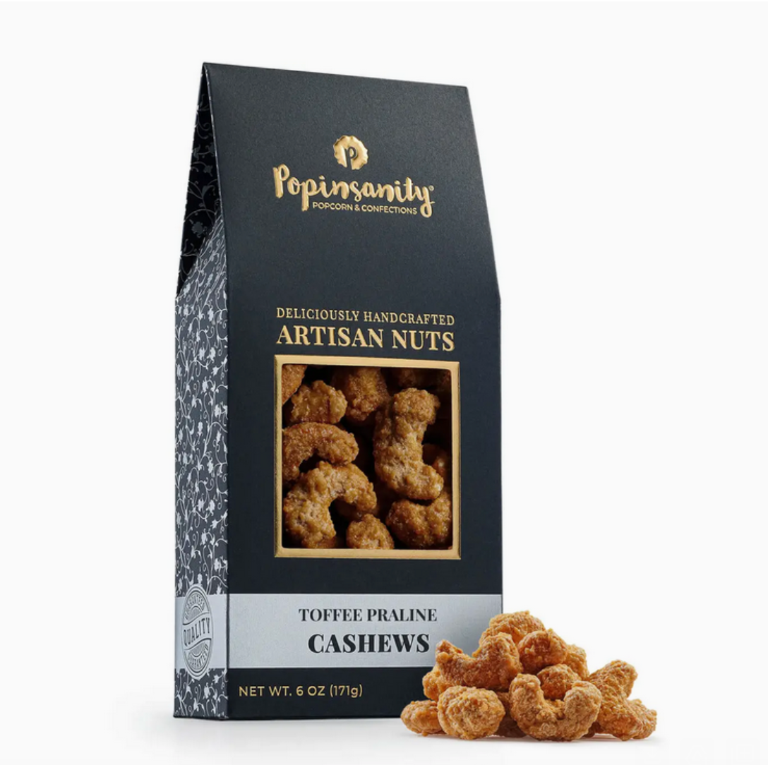 A close-up view of crunchy roasted cashews coated in a rich toffee praline. The cashews have a glossy, caramelized coating that highlights their sweet and creamy texture.