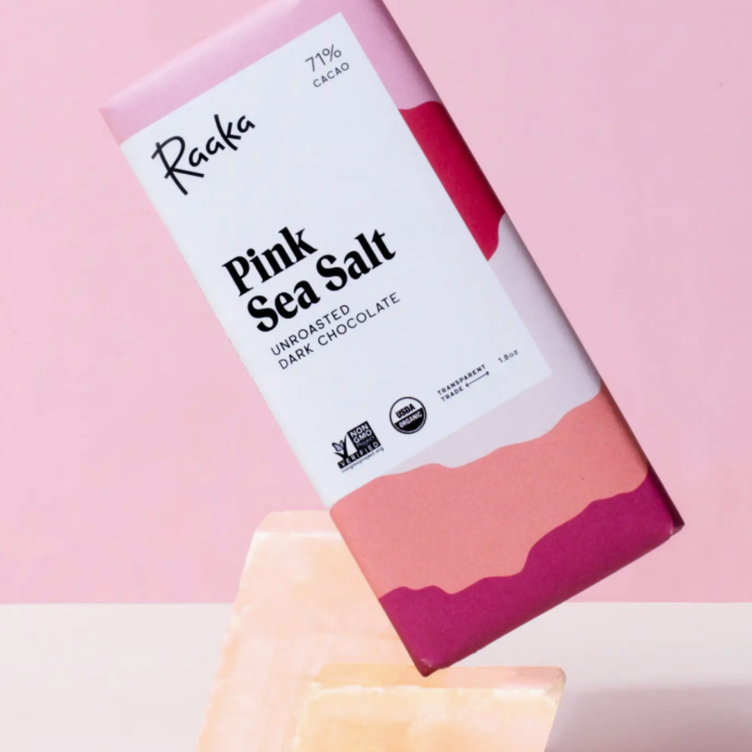 Raaka Pink Sea Salt chocolate bar packaging on a pink background.