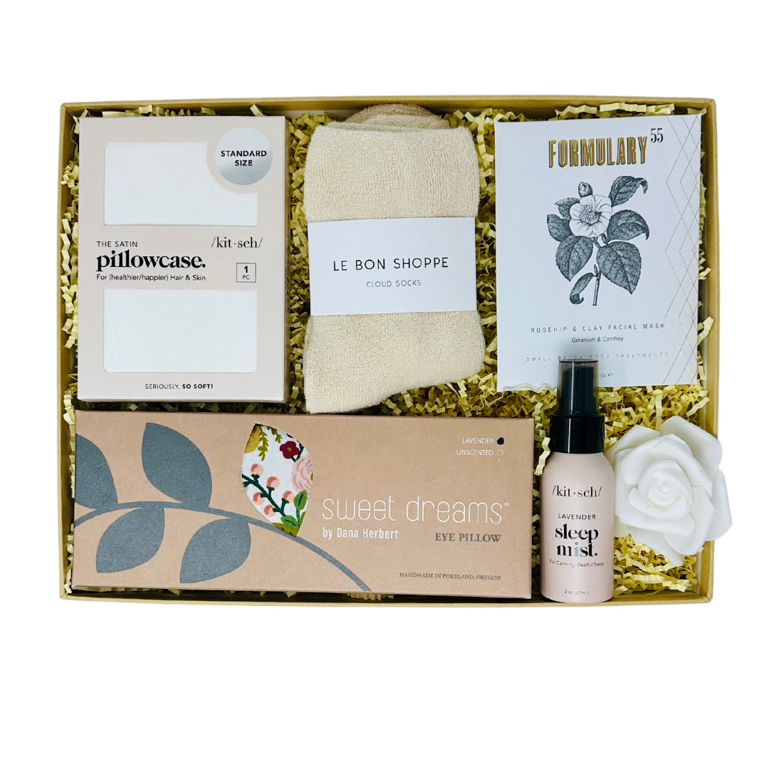 Elegant SATIN DREAMS gift box with luxurious self-care essentials, including satin pillowcase, lavender eye pillow, sleep mist, and cozy socks.