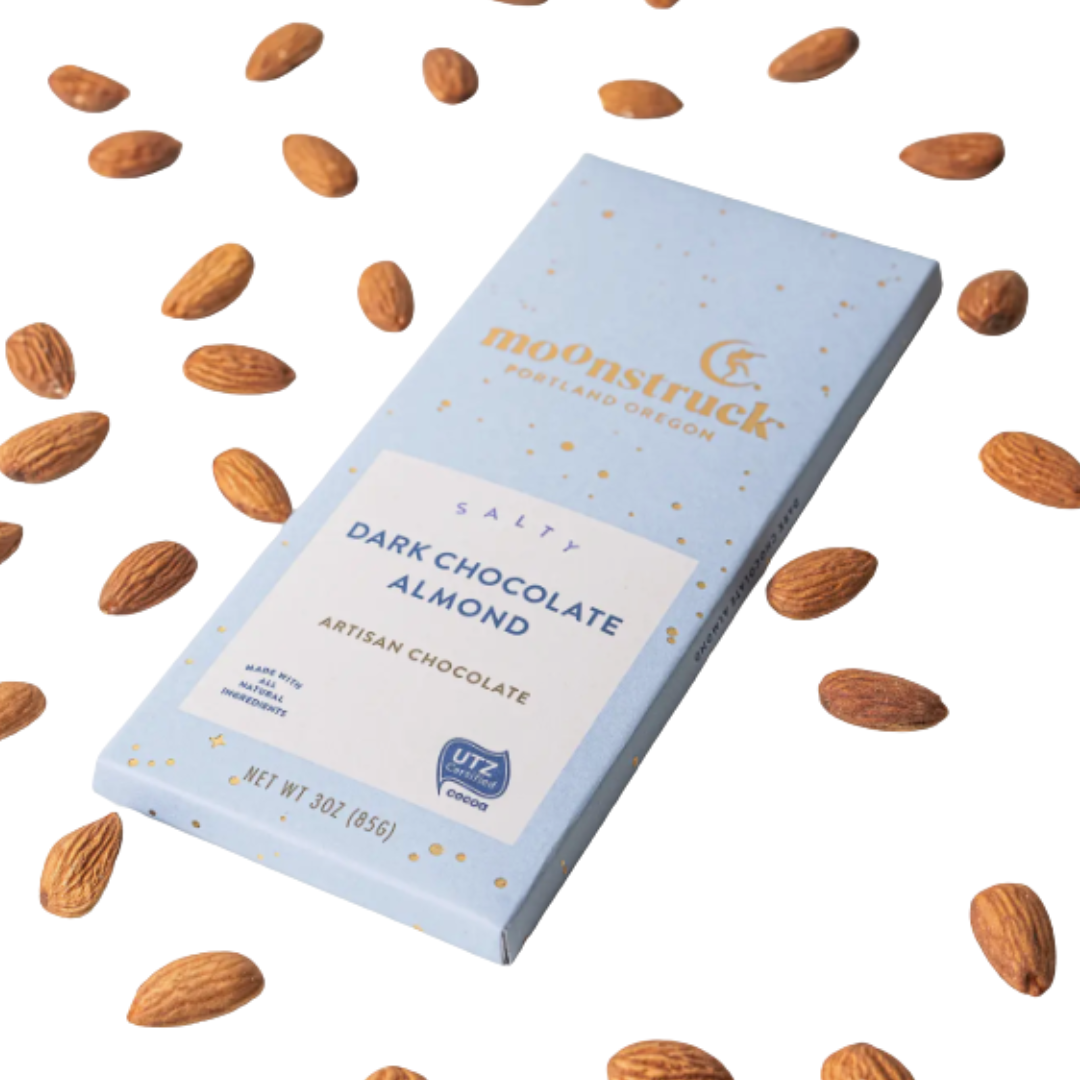 Moonstruck dark chocolate almond bar with almonds scattered around on a white background.