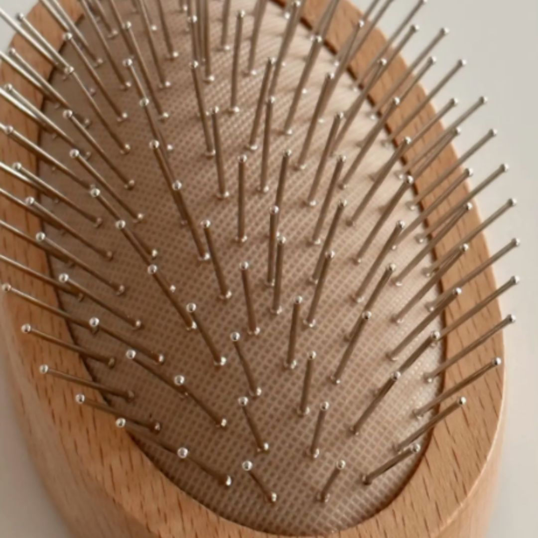 Close up image of a Daily Habits all natural beechwood scalp massage brush in an oval shape that fits nicely in your palm. Promotes hair growth and relieves tension!