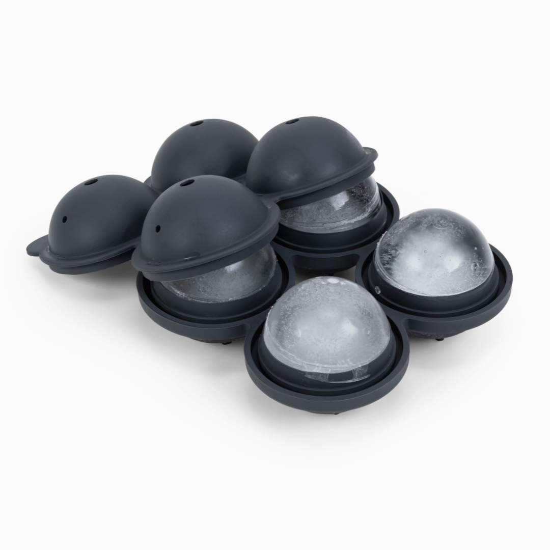Black ice cube tray with spherical molds on a white background. The tray holds four spheres that are 2.5 inches each.