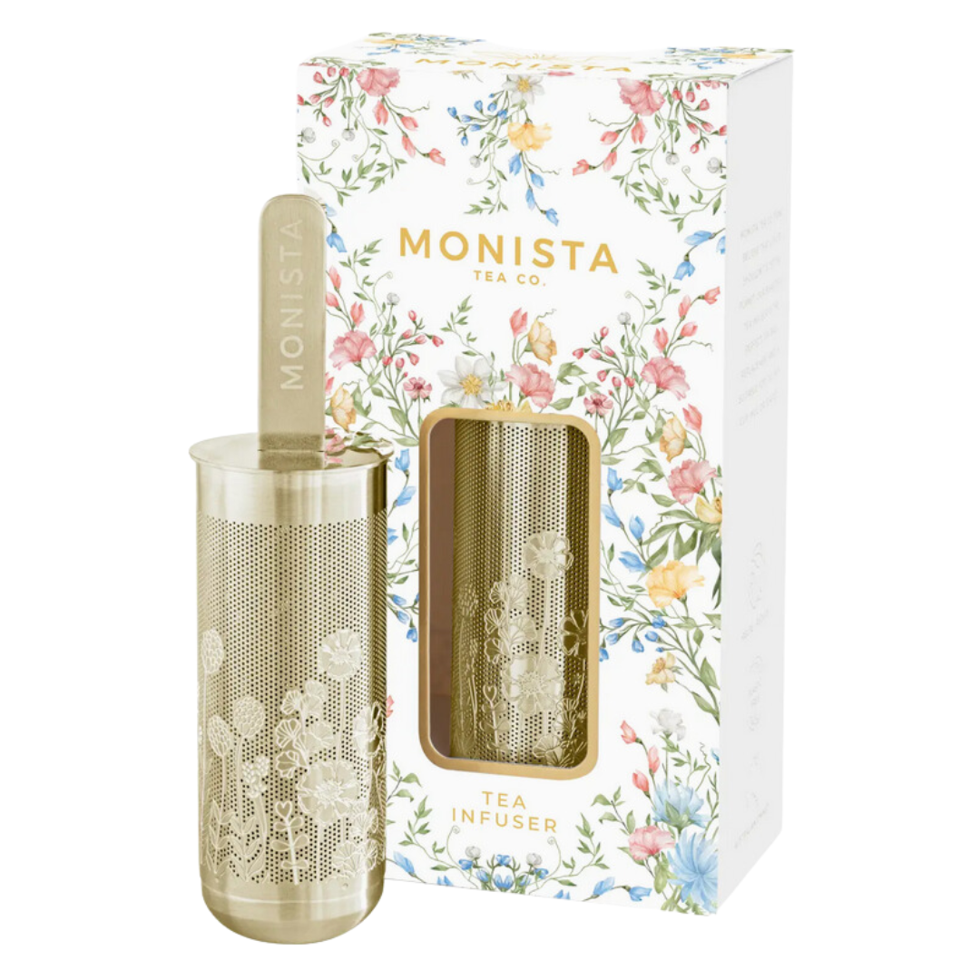 The Monista Tea Co. Organic Persian Mint Tea gift set, featuring a canister of tea and a stylish infuser, surrounded by fresh mint leaves and rose petals, emphasizing its organic ingredients.