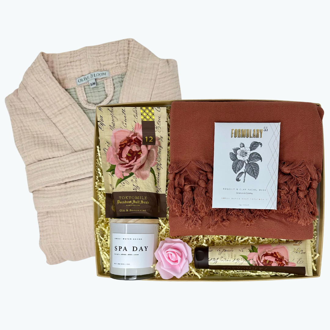 Gift set with a towel, a candle, bath salt and shower gel in a box on a white background.