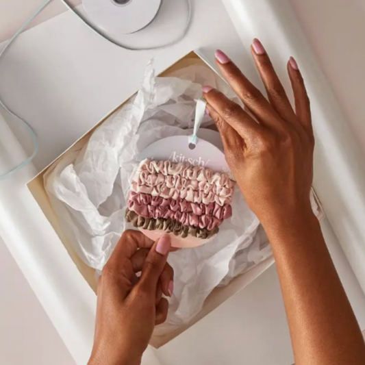 Close-up of silky-soft satin scrunchies with ruched details, perfect for gifting or personal use, showcasing their ability to hold hair securely without causing damage.