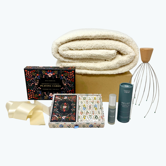 Gift set with blanket, playing cards, head massager, aromatherapy and other items on a white background