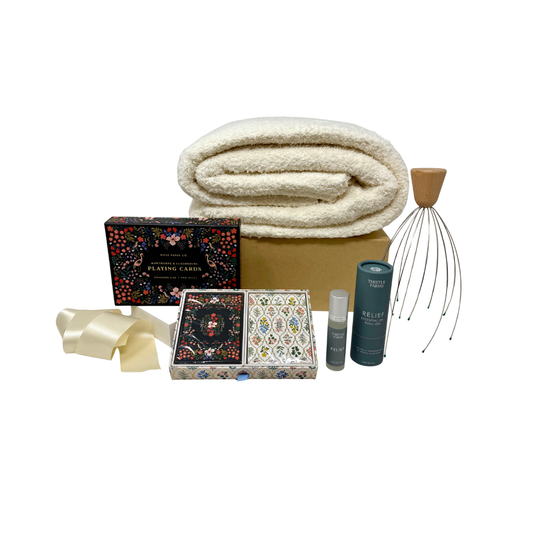 Collection of items including a folded blanket, playing cards, head massager, and other products on a white background.