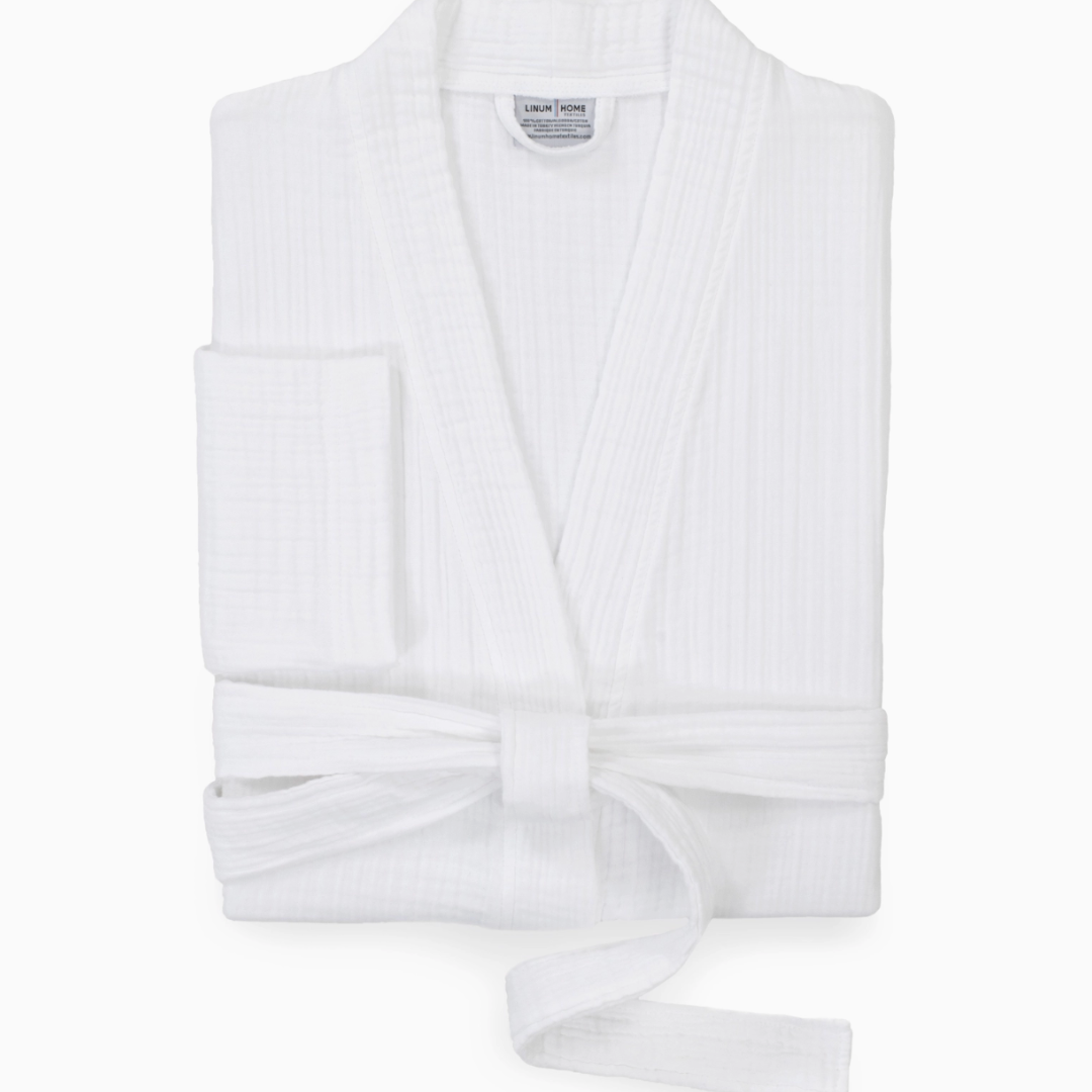 A close-up of the adjustable waist tie on a plush white spa robe, allowing for a customized fit. The robe features two side pockets for added convenience and practicality.