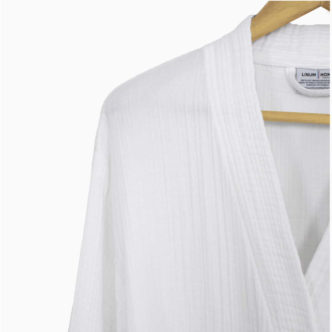 A close up view of a lightweight white spa robe crafted from long-staple Turkish cotton, emphasizing its remarkable softness and breathable design, perfect for relaxing at home or after a bath.