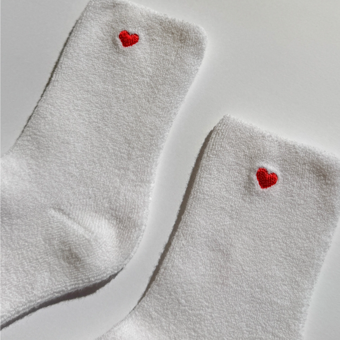 White sock with red embroidered heart.
