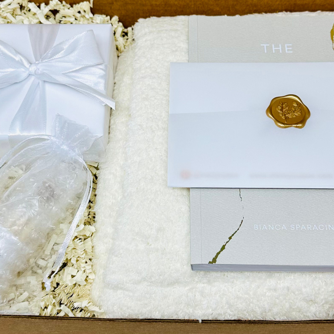 Express heartfelt condolences with this curated gift box. Thoughtfully curated sympathy gift box showcasing a serene arrangement of items, such as a candle, a soft throw blanket, and a sympathy card, intended to provide comfort and solace.