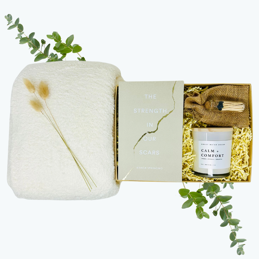 Gift set with a candle, blanket, and decorative items on a white background.