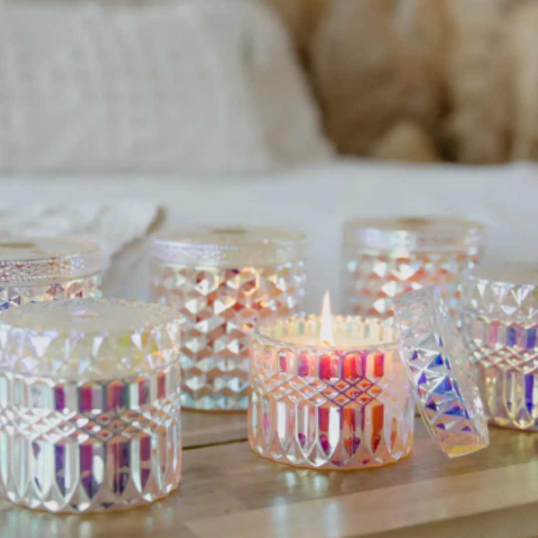 Wooden coffee table with four pink iridescent cut Glass Shimmer Candles, radiating warm glow, a perfect addition to your Me To You Box – customize and create the ultimate gift experience!