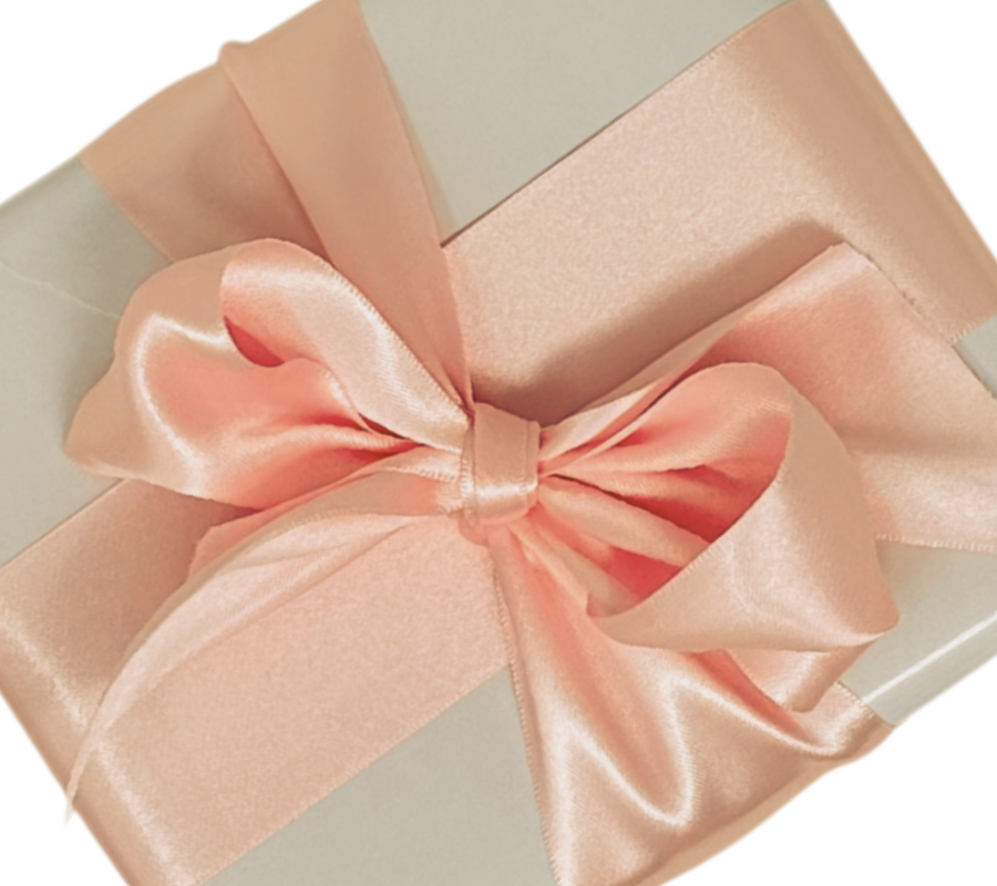 A square gift box wrapped in white gloss paper with wide pink satin ribbon tied in a bow and displayed on a white background.