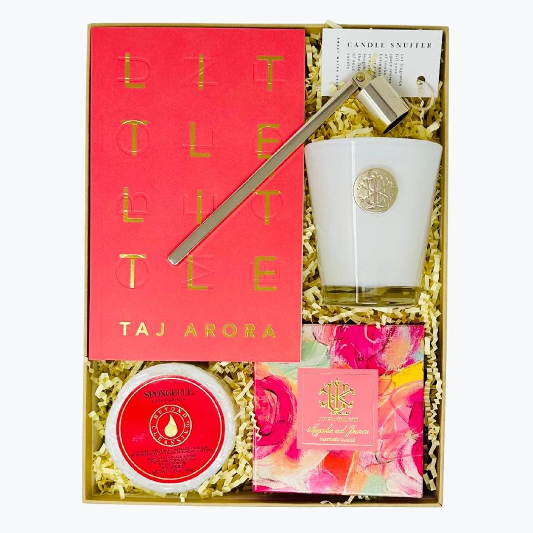 Gift set with Spongelle, candle, candle snuffer by Sweet Water Decor and book by Taj Arora on a white background.