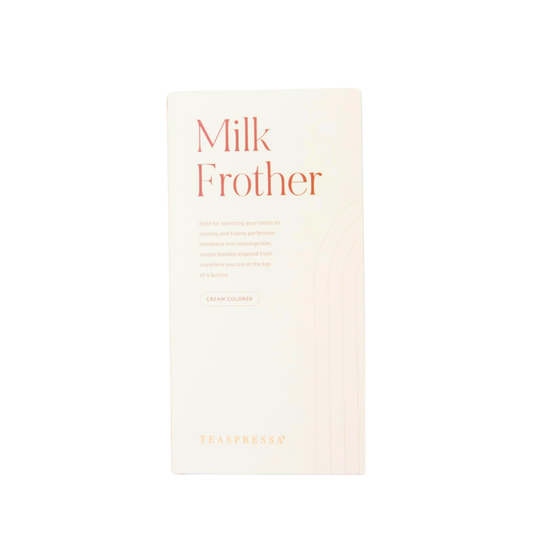A cream-colored rectangular box for TEASPRESSA Milk Frother, featuring orange text and a subtle wavy line pattern, set against a plain white background.