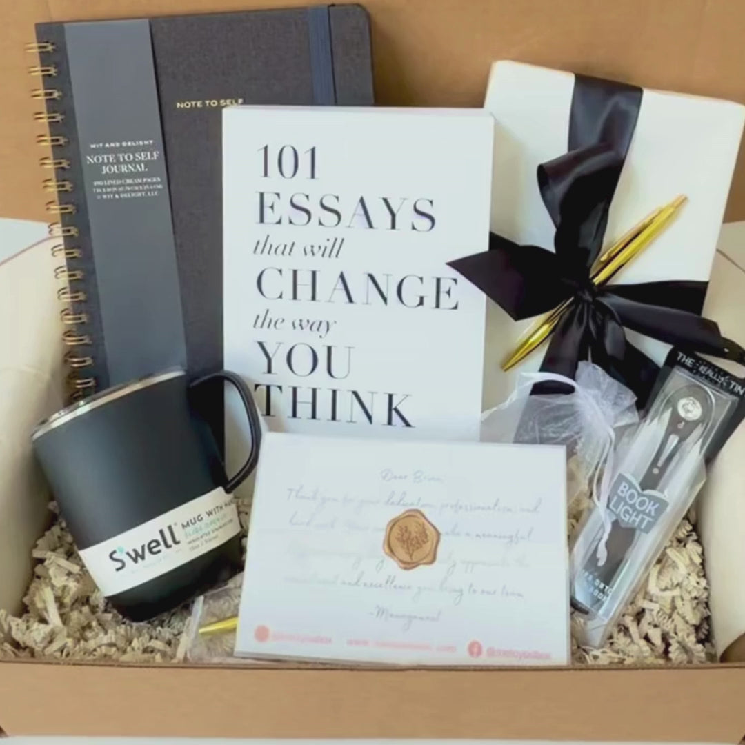 Gift box with linen journal, 101 Essays The Will Change The Way You Think book, book light, S'well tumbler, pen and gift card in a decorative box.