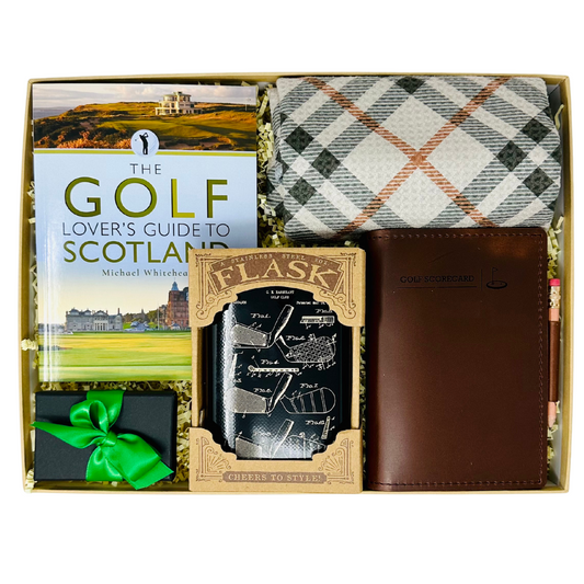 'In The Zone' gift box from Me To You Box, featuring a leather score book with pencil, a stylish plaid towel, golf ball markers, a sleek flask, and an enticing book on golf in Scotland.