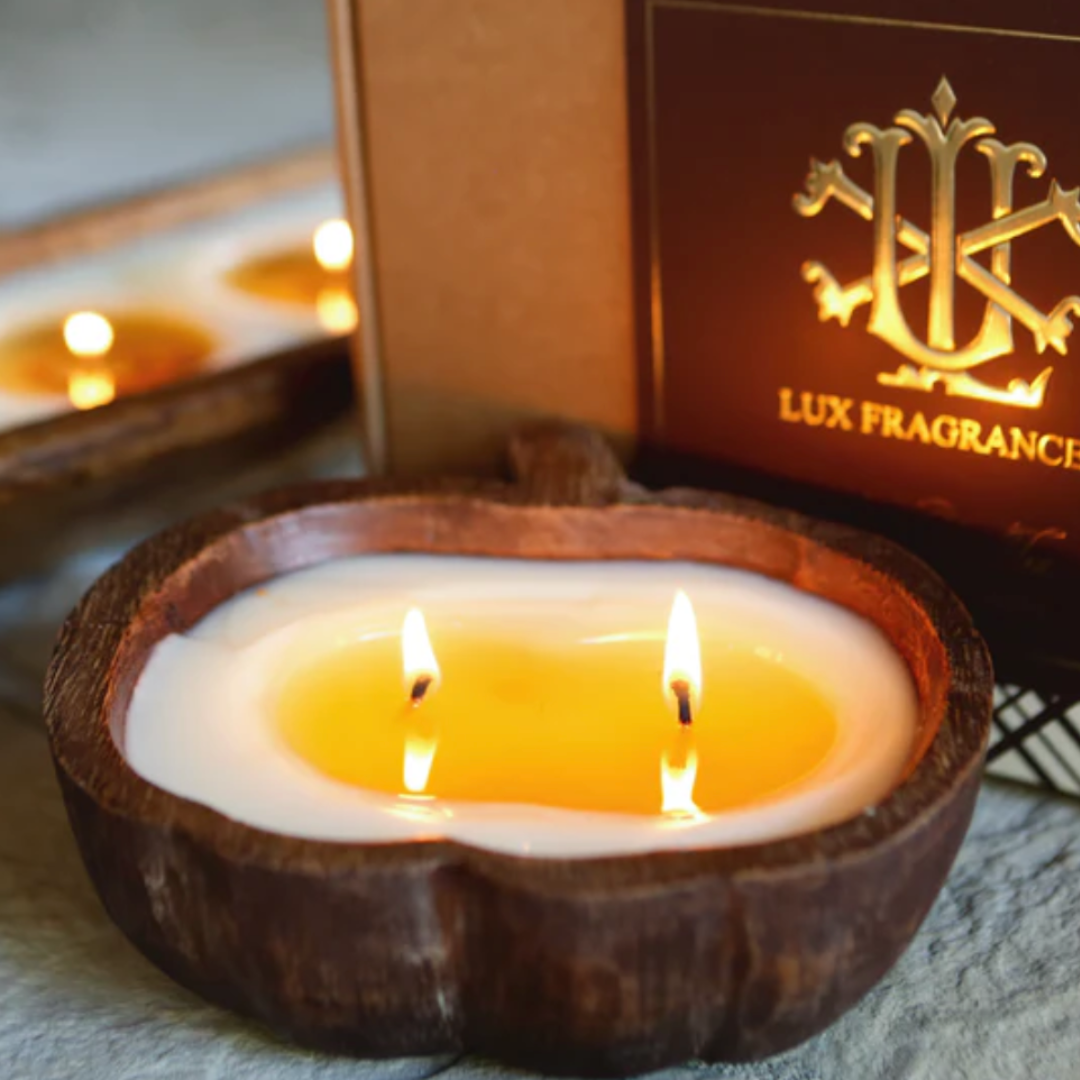 Invigorating pumpkin-scented candle in a stylish wooden bowl, creating a warm and fragrant atmosphere for fall celebrations.