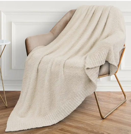 Cozy 50x60 inch solid cream knit blanket with a soft, textured fleece finish, perfect for enveloping the recipient in warmth and tranquility during moments of solitude or reflection.