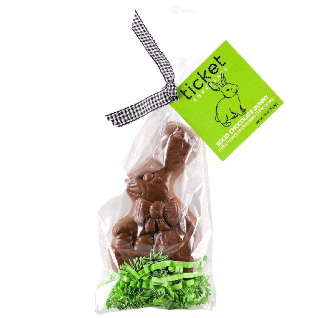 A solid milk chocolate Easter bunny by Ticket Chocolate, crafted from rich, gourmet chocolate and accented with a charming bow. This 1.9-ounce festive treat makes a perfect Easter gift for chocolate lovers and a delightful addition to any Easter basket.